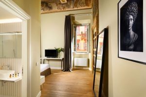 Cozy room at Hotel della Posta, featuring frescoes and modern amenities.