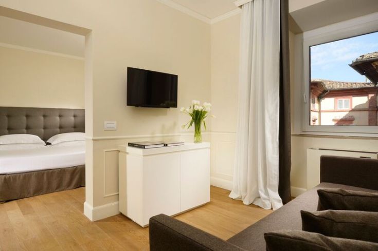 Cozy room with TV and a view of an Umbrian urban landscape, ideal for a comfortable stay.
