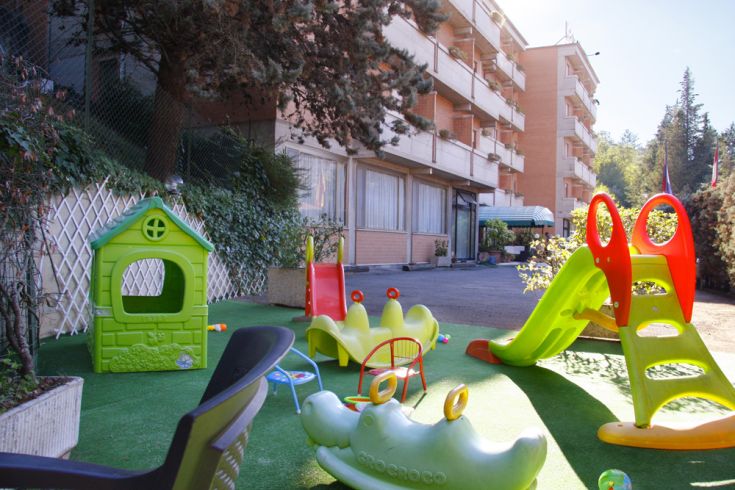 Spielplatz für Kinder mit Außenausstattung, eingebettet in eine grüne und entspannende Umgebung.