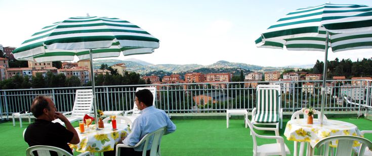 Zwei entspannte Männer in der Sonne, umgeben von grün-weißen Streifenregen, genießen eine ruhige Aussicht.