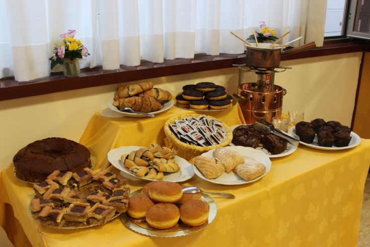 Ein Sortiment an Süßigkeiten und Desserts, die auf einem Tisch in einer gemütlichen Umgebung präsentiert werden.