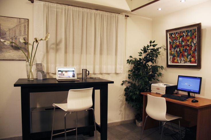 Ein einfacher Arbeitsplatz mit Computern und Pflanzen, ideal zum Entspannen während Ihres Aufenthalts.