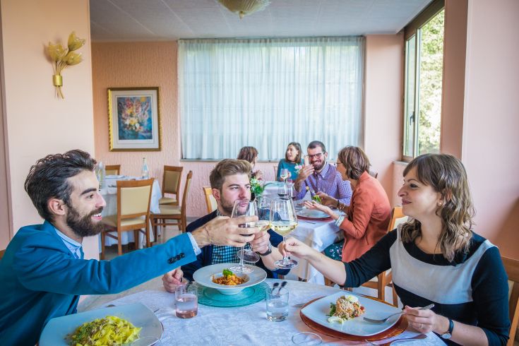 Ein Treffen mit Freunden in einem gemütlichen Restaurant, wo sie ein Essen genießen und gemeinsam anstoßen.