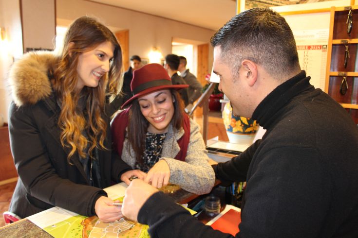 Two people are reviewing a map with a hotel staff member to plan their visit to the area.