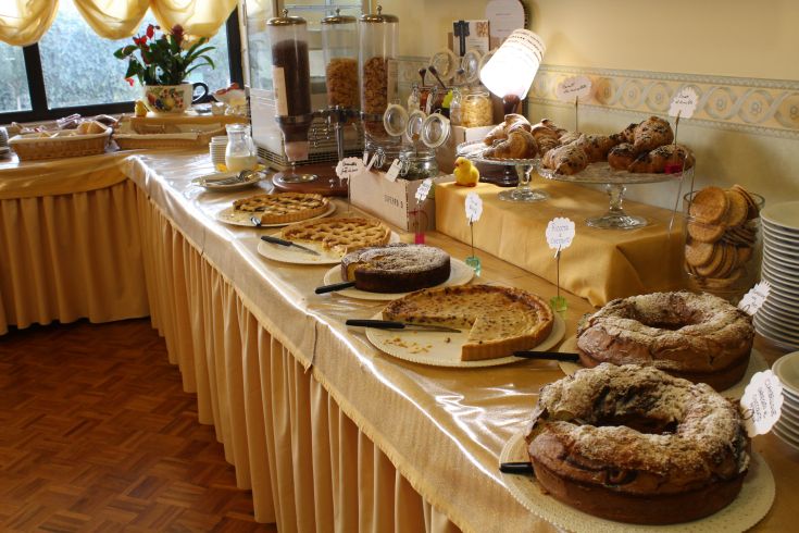 A rich and abundant breakfast featuring fresh pastries and selected ingredients, served in a cozy environment.