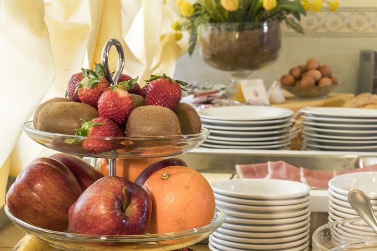 A colorful selection of fresh fruits served in a cozy hotel dining room, perfect for starting the day.