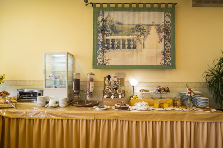 Rich breakfast with sweets, bread, and chocolate in a cozy setting.