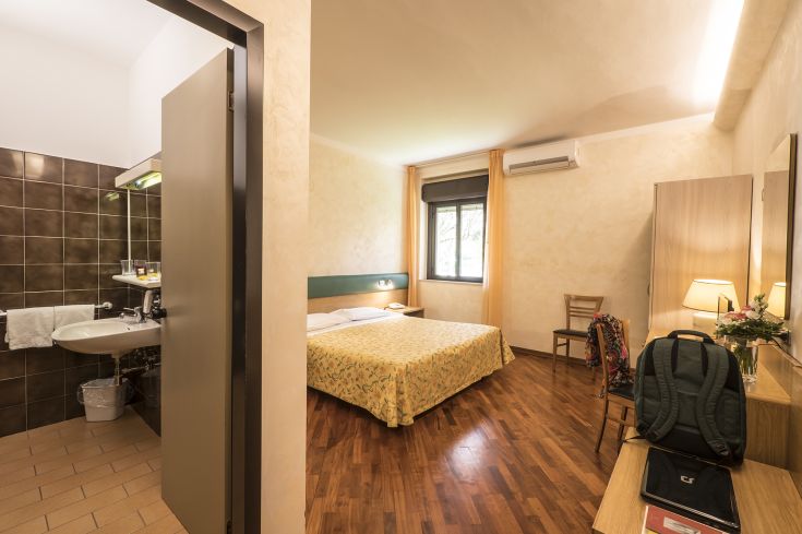 Quiet hotel room with a double bed and private bathroom, offering a relaxing atmosphere.