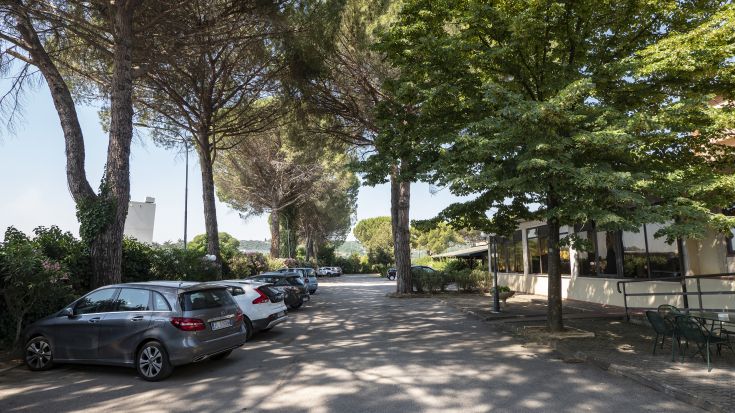 Spacious parking lot at a hotel, surrounded by greenery, perfect for a peaceful stop.