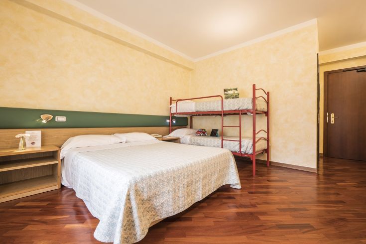 Simple room with a double bed and a bunk bed, ideal for families with children.