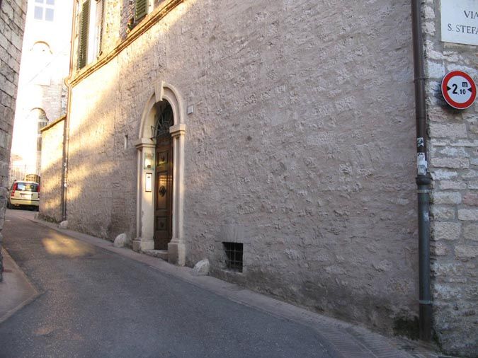 A stone road leading to an elegant gate, featuring a historic sign at the entrance.