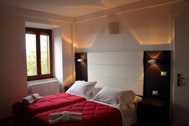 Simple room with single beds and warm lighting. A peaceful view of the surrounding city.