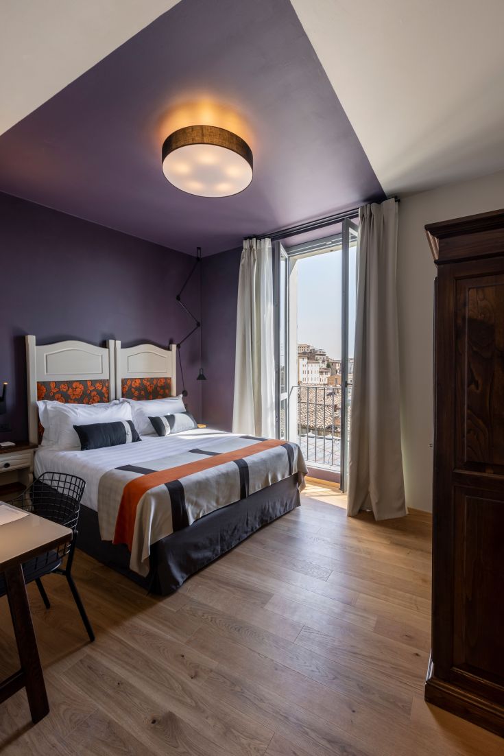 Stanza ben illuminata con arredamenti moderni, finestra ampia e dettagli curati.