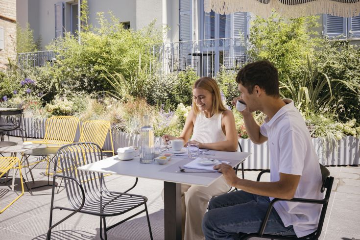 Colazione nel giardino in un'area ordinata, immersi in un'atmosfera tranquilla e luminosa.