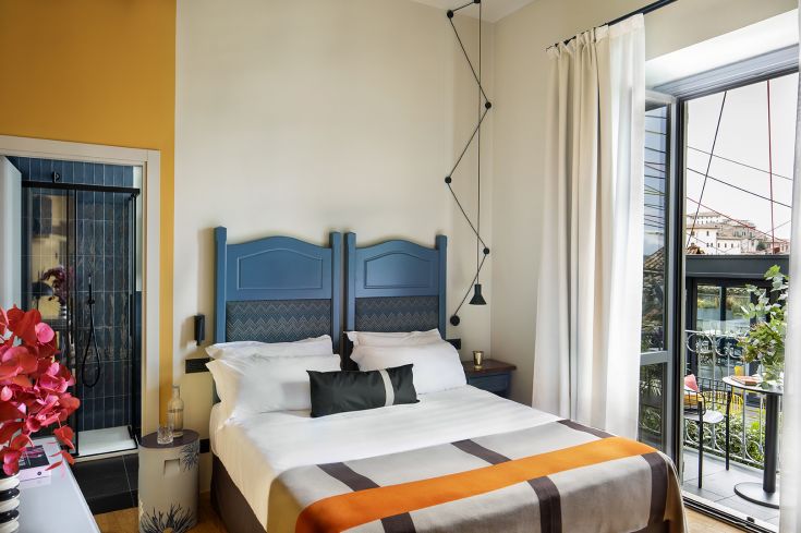 Camera del Design Hotel con elementi di arredo moderni e grandi finestre che offrono luce naturale.