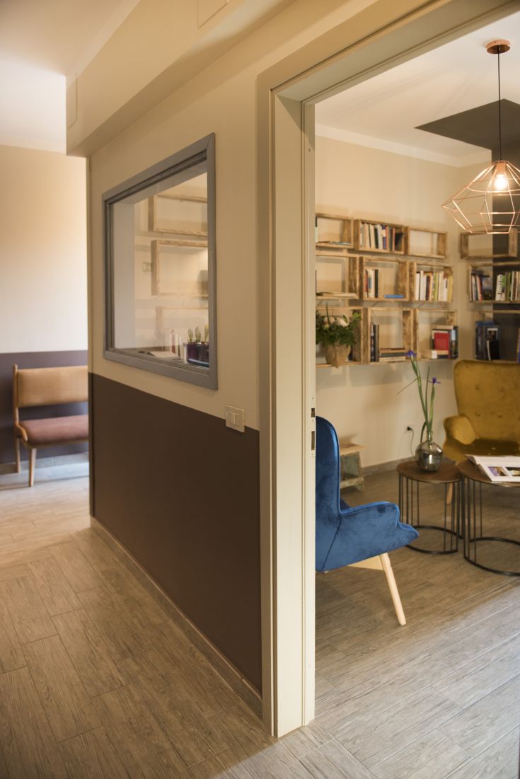 Ambiente confortevole con mobili in legno e dettagli in vetro, ideale per rilassarsi e leggere.