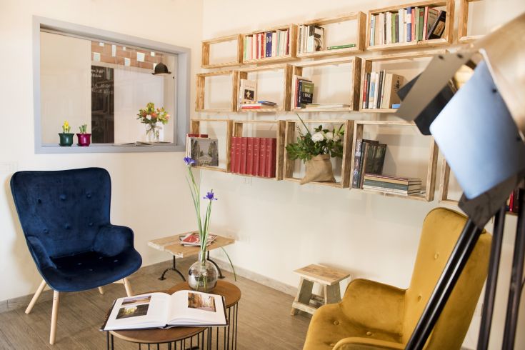 Ambiente confortevole con poltrone e una libreria, perfetto per la lettura e il relax.