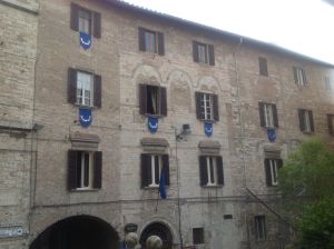 L'area storica presenta architetture con finestre decorate in tonalità blu. Un'atmosfera caratteristica di Perugia.