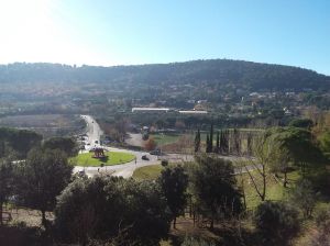 A hilly scene with lush vegetation and a gently winding stone road through the hills.