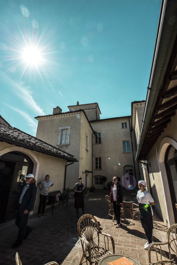 A 16th-century building with a sunny courtyard, a passage for visitors in a historic setting.