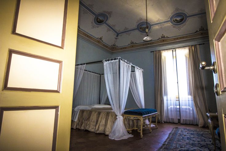 Room with a decorated ceiling and canopy bed, serene and cozy atmosphere.