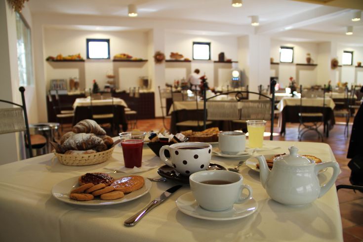 Petit déjeuner préparé avec soin, comprenant des douceurs et des boissons servies dans un cadre confortable.