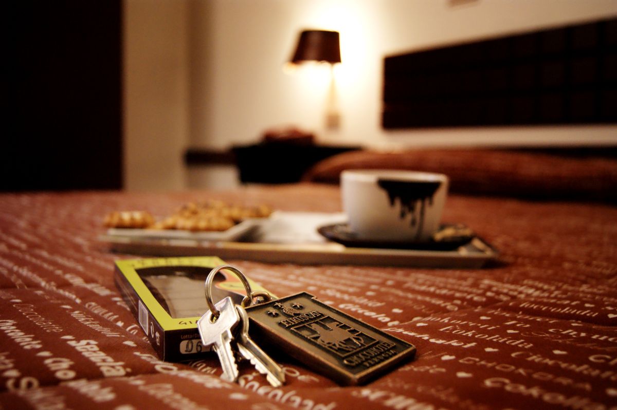Un angolo di un hotel con chiavi, dolci e una tazza di cioccolato caldo.