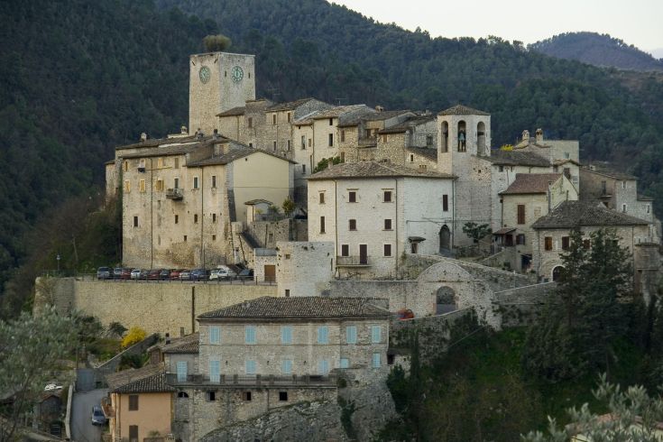 Charmant village médiéval en Ombrie, avec des maisons en pierre et une horloge sur la tour.