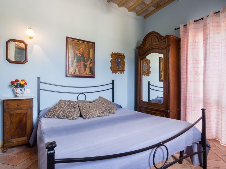 Chambre simple avec des meubles traditionnels dans un environnement serein et rustique.