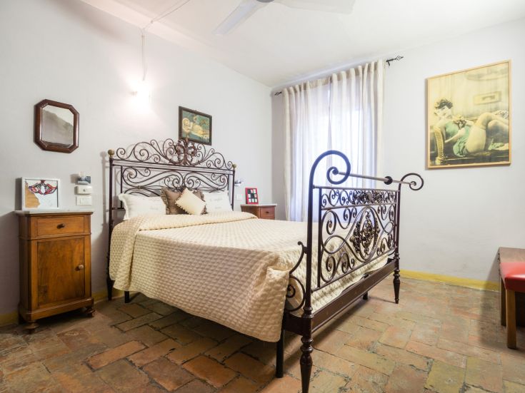 Une chambre au design simple avec des lits en fer forgé et des meubles de style classique.