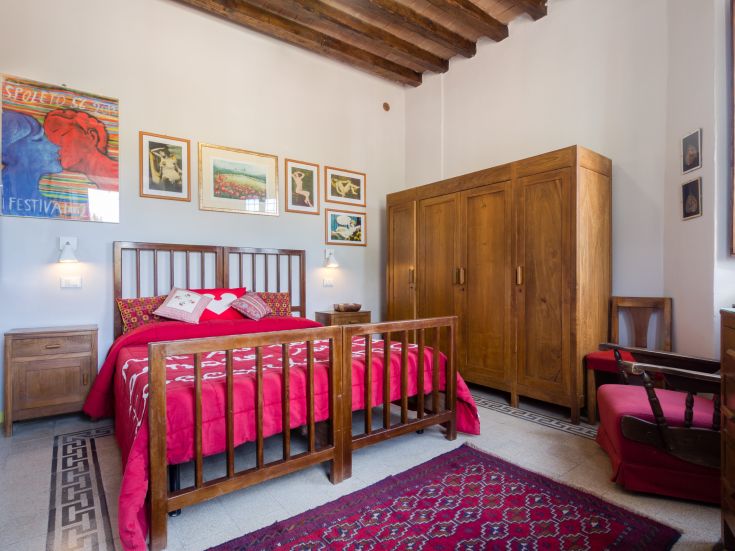 Une chambre double confortable avec des lits en bois et des détails vintage, bien éclairée et accueillante.