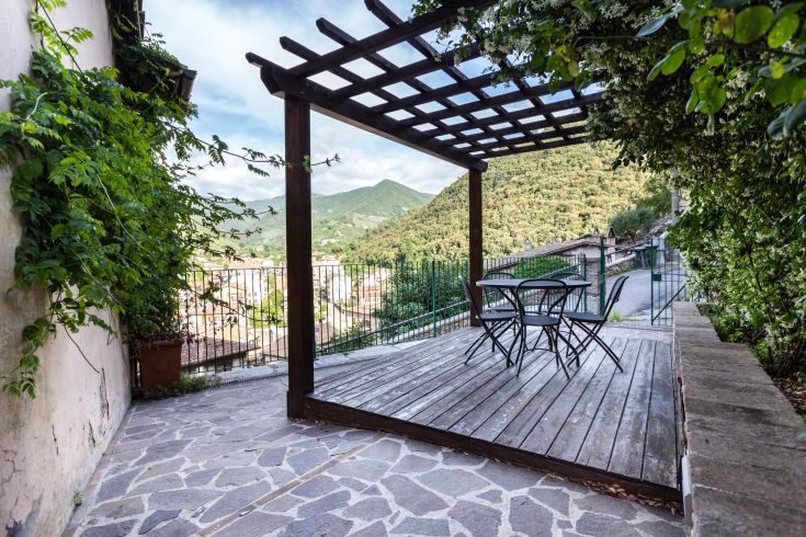 Une pergola accueillante entourée de verdure, parfaite pour des moments de détente en plein air.