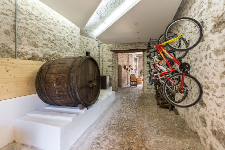 Un couloir simple avec un fût en bois et des bicyclettes montées au mur.