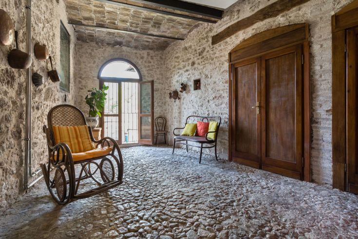 Intérieur confortable avec murs en pierre et sol en pierre, décoré de manière simple.