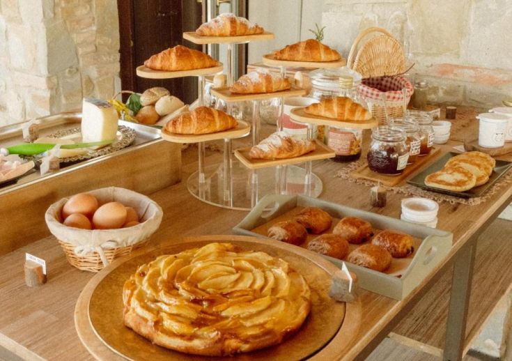 Petit déjeuner en plein air dans une ferme avec des croissants frais et des pâtisseries assorties dans une ambiance relaxante.