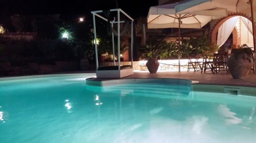 Piscine d'eau salée entourée de verdure, offrant une atmosphère calme et accueillante.