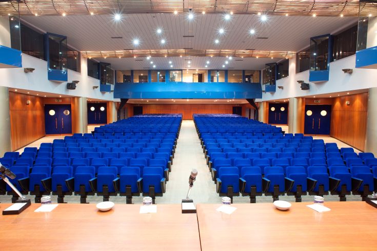 Spazio ampio con sedute blu confortevoli, adatto per conferenze e manifestazioni.