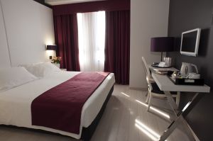 Camera semplice e confortevole, dotata di un letto matrimoniale e di uno spazio per lavorare.