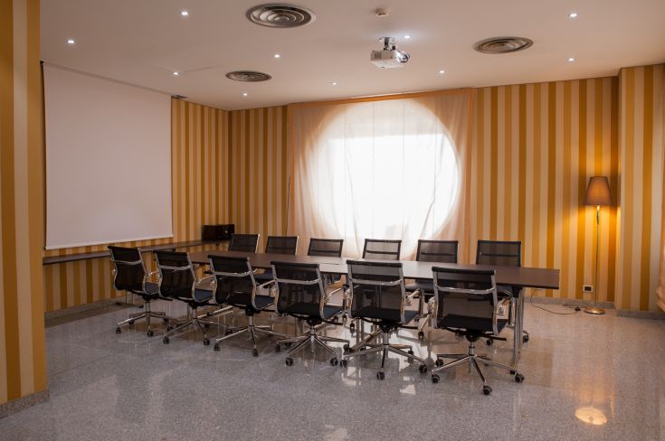 Ambiente di lavoro spazioso e ben illuminato, adatto per riunioni e incontri professionali.