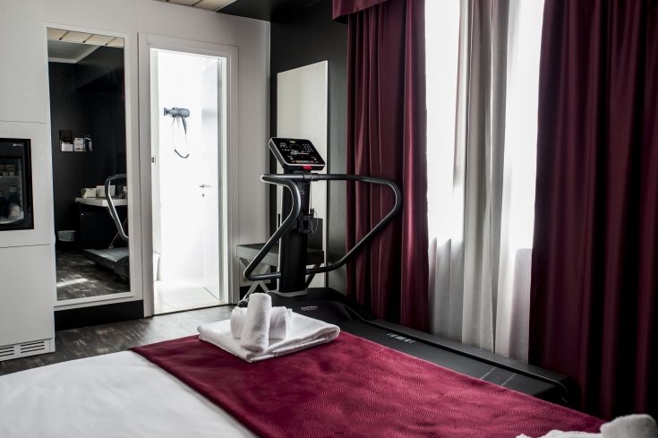 Camera con attrezzi per il fitness e decorazioni sobrie, adatta per il riposo e l'attività fisica.