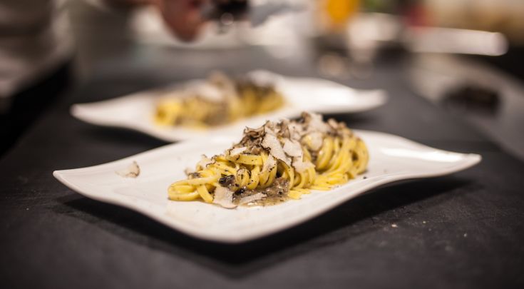 Pasta preparata con tartufo, servita su un semplice piatto bianco.