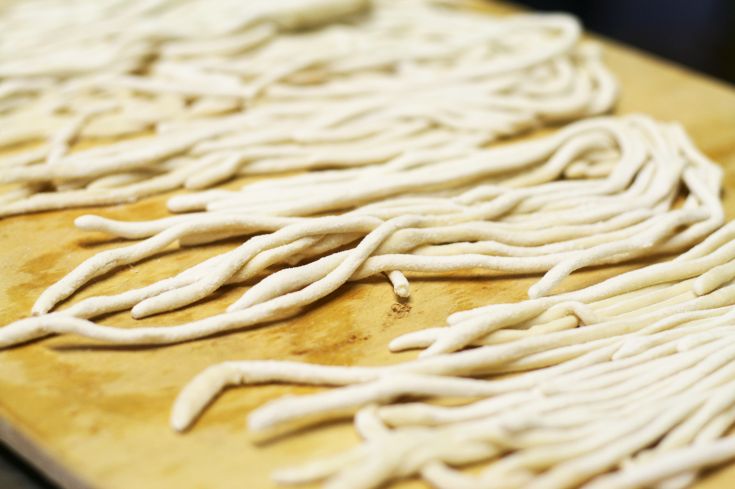 Frische pastastreifen auf einer Arbeitsfläche ausgebreitet. Perfekt für traditionelle Rezepte.