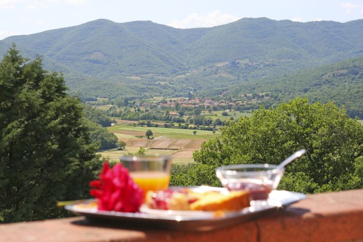 Frühstück in einem Raum mit Fenstern, die auf die Hügel blicken, und einem typischen umbrischen Bauernhaus, ideal für Entspannungsmomente.