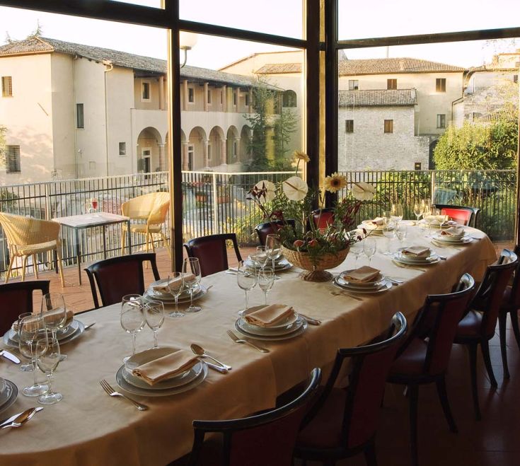 A simple decorated table in a restaurant overlooking a garden.