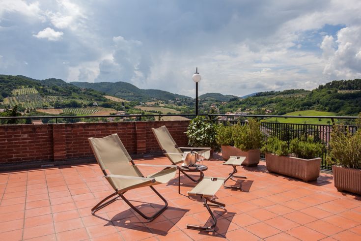 Terrace with loungers for relaxation and a view of the surrounding hills.