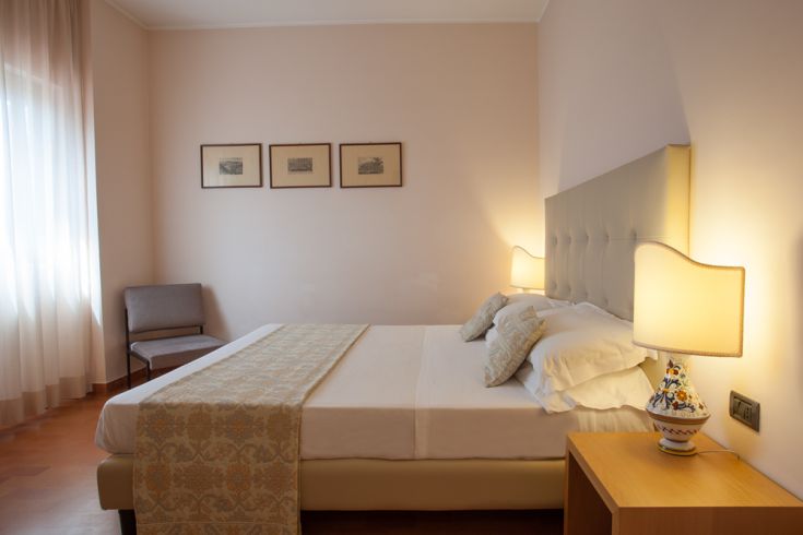 A bright and spacious room featuring a double bed and simple decorations.