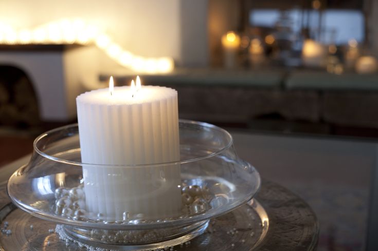 A lit candle on a simple plate, creating an intimate and relaxing atmosphere.