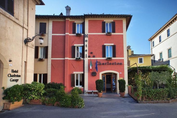 A cozy hotel in the center of Spoleto, surrounded by greenery and featuring distinctive architectural elements.