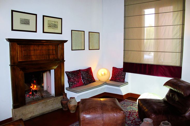 A cozy corner with a fireplace, sofas, and furniture in a serene environment.