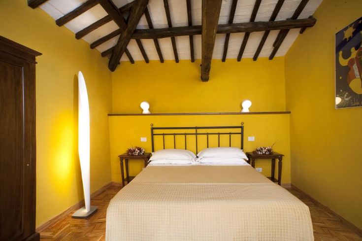 Simple room with yellow walls and functional furniture, perfect for a peaceful stay.